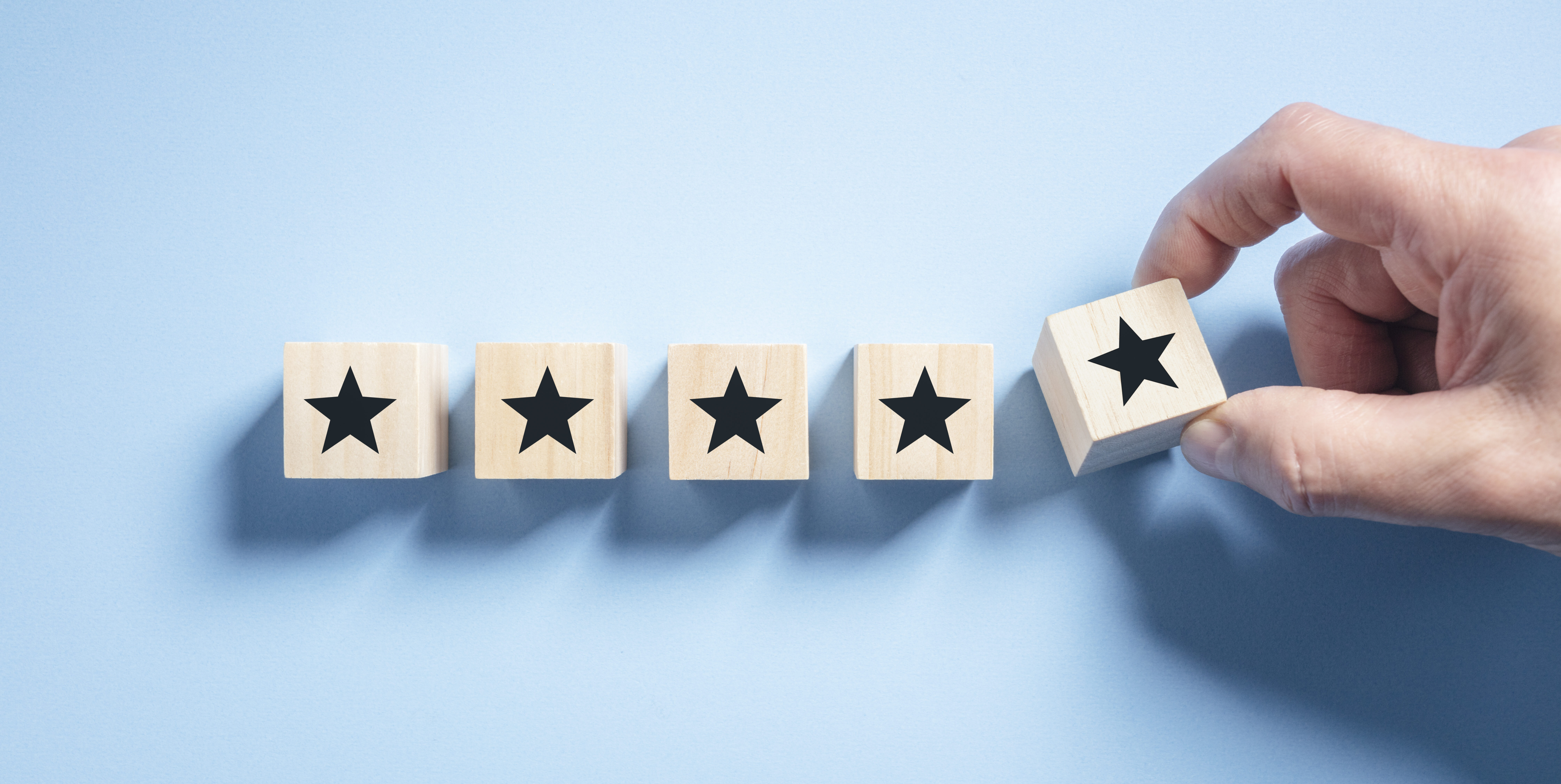 Customer experience feedback rate satisfaction experience five star rating placing wooden blocks on blue background