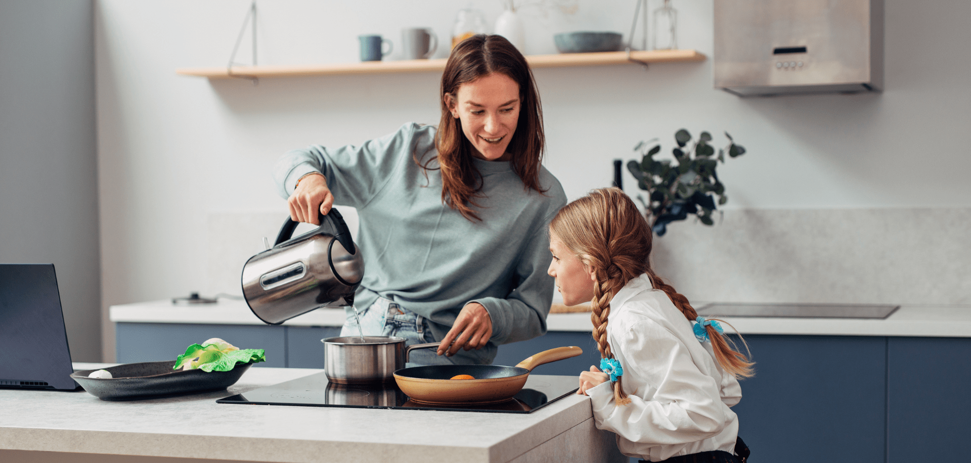 Mum with daughter in the kitchen with a boiler | Harvey Water Softeners
